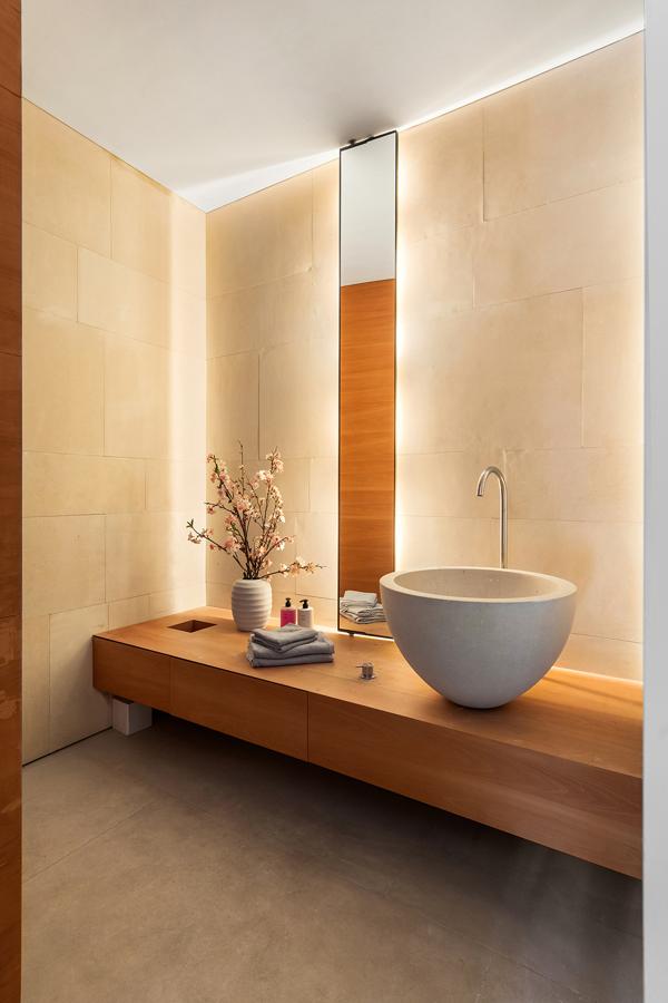 El loft minimalista de Kim Kardashian. El baño es un oasis de paz y tranquilidad revestido de madera y piedra, materiales que le aportan la misma calidez y limpieza que posee toda la casa. Destaca una isla de piedra, similar a la de la cocina, sobre la que se organiza todo.