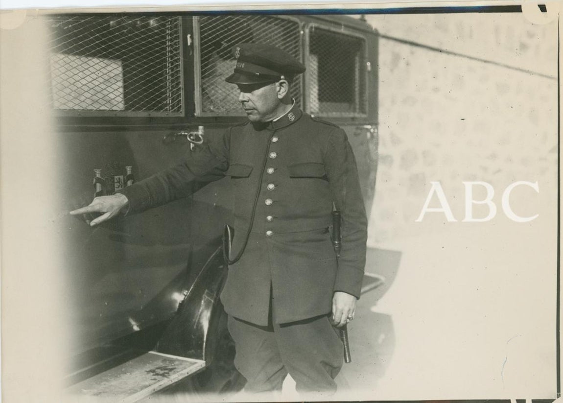 Un agente de la Guardia de Asalto muestra los orificios de bala en el camión atacado. 