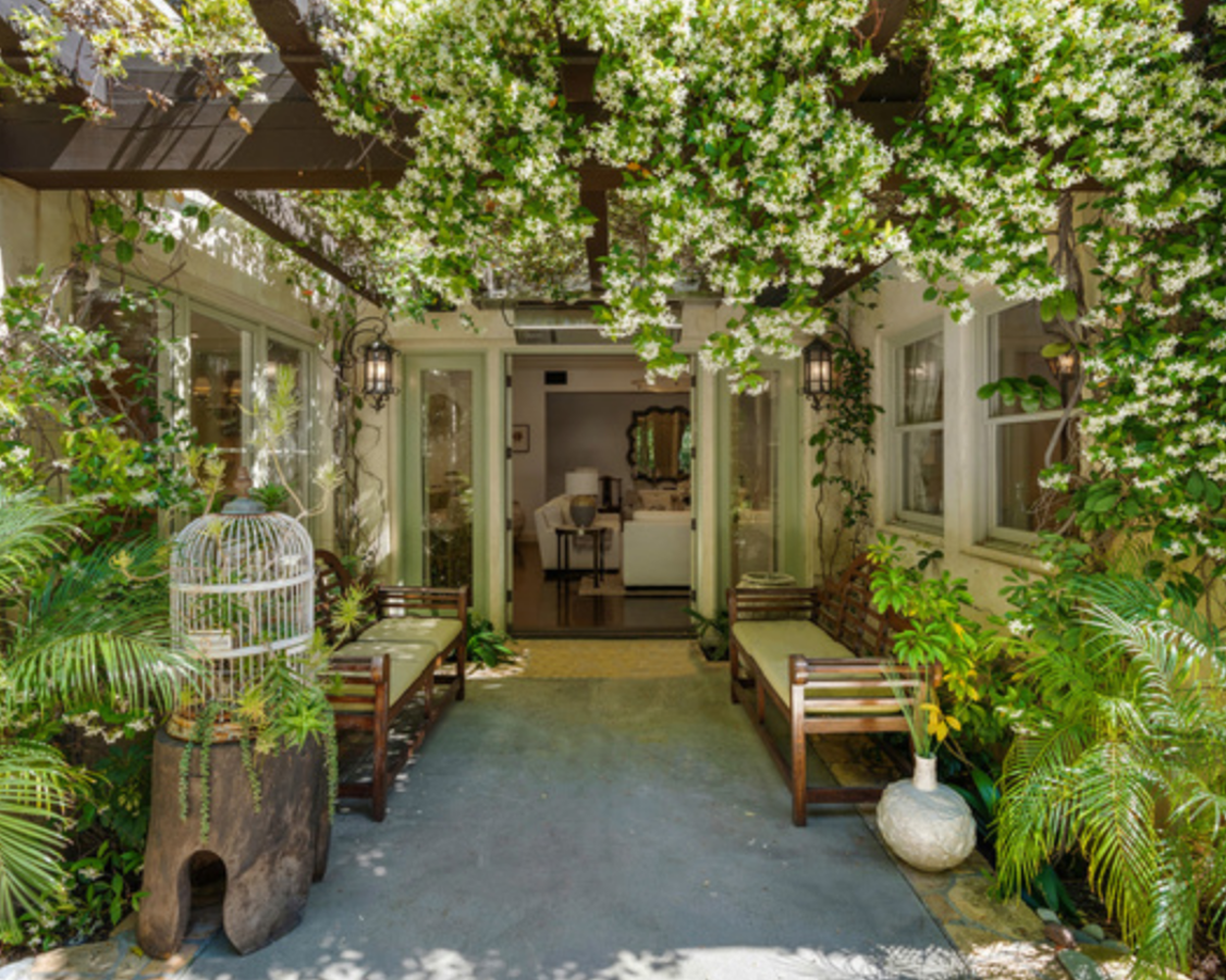La mansión de Beverly Hills de Britney Spears. Bajo una pérgola de madera, con acceso directo al salón principal y rodeada de plantas está este relajante espacio exterior con butacas, un lugar ideal para pasar las noches de verano en compañía de la familia o amigos.