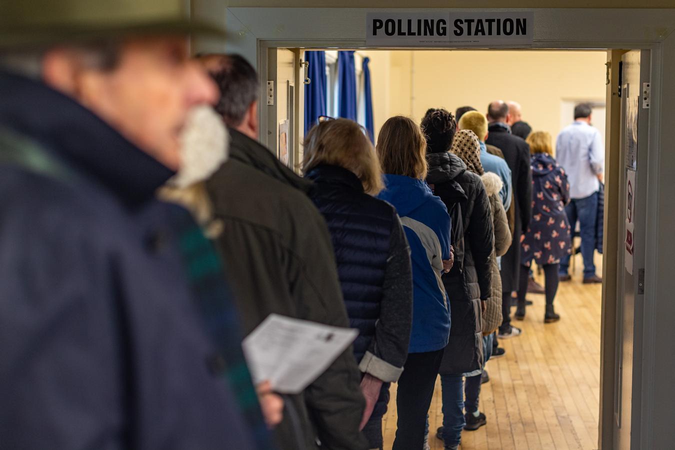 Decenas de ciudadanos guardan cola en la estación de Berdmonsey de Londres para emitir su voto. 