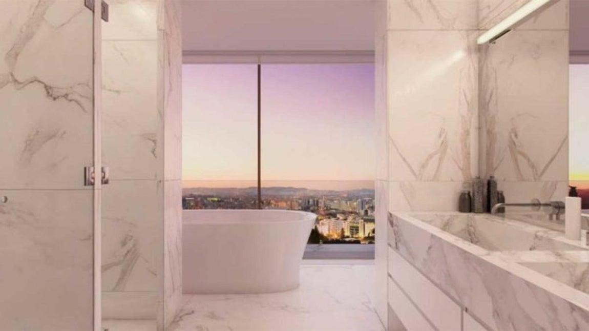 Ático Dúplex Castilho,33. El cuarto de baño de la suite principal es de mármol de carrara blanco manchado en tonos grises, de tipo spa, con zona de aguas, chorros y un gran espacio para ducha. Se amuebló de forma minimalista con piezas de lujo. La más exquisita, una bañera exenta situada en la pared acristalada. Desde su interior Cristano Ronaldo podrá darse un baño de espuma y gozar de las soberbias vistas de la capital a la vez