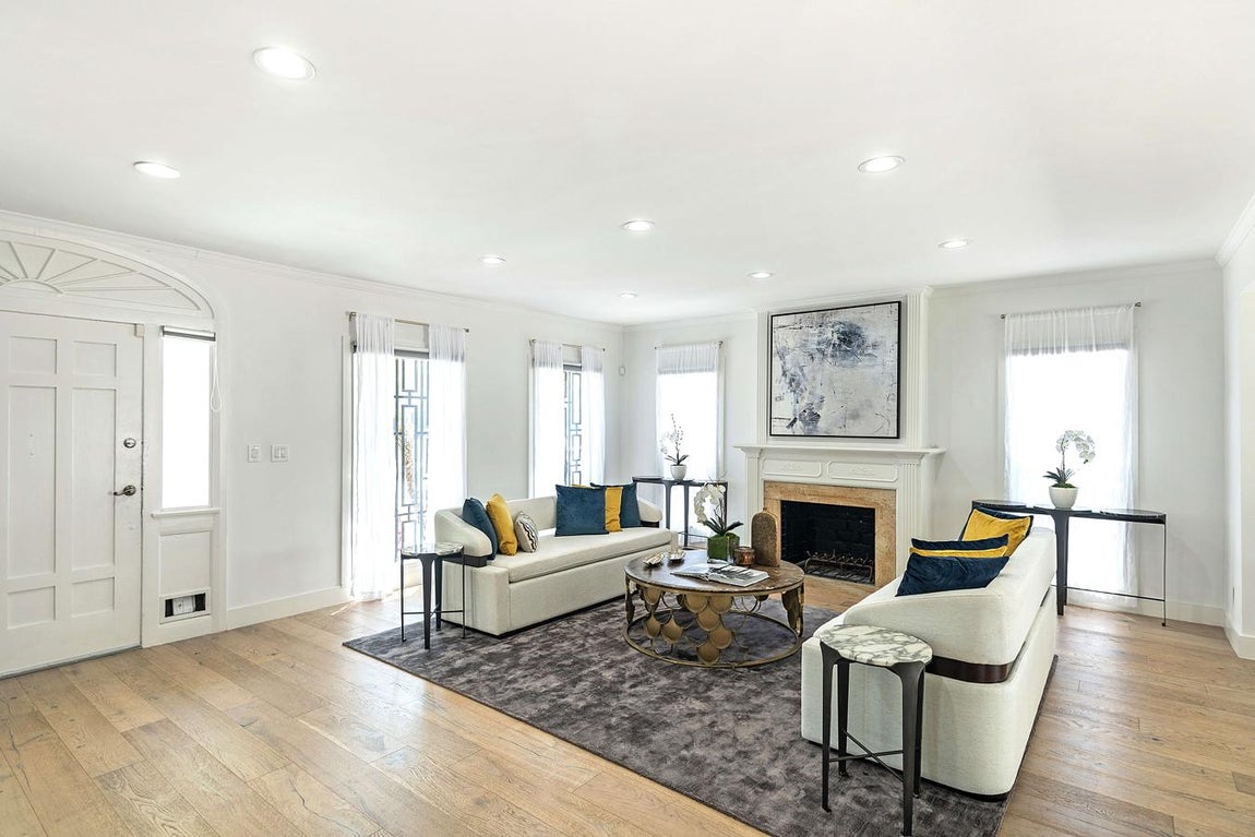 Meghan Markle en Hancock Park. La actriz ejercía en Los Ángeles en esta casa de 210 m2 en la que el color blanco, elementos arquitectónicos naturales y los muebles de diseño son de referente. El salón es la estancia más destacada de la casa: tiene pavimento de madera, es muy espacioso y está presidido por una suntuosa chimenea. Frente a ella una mesa de autor y muebles selectos.