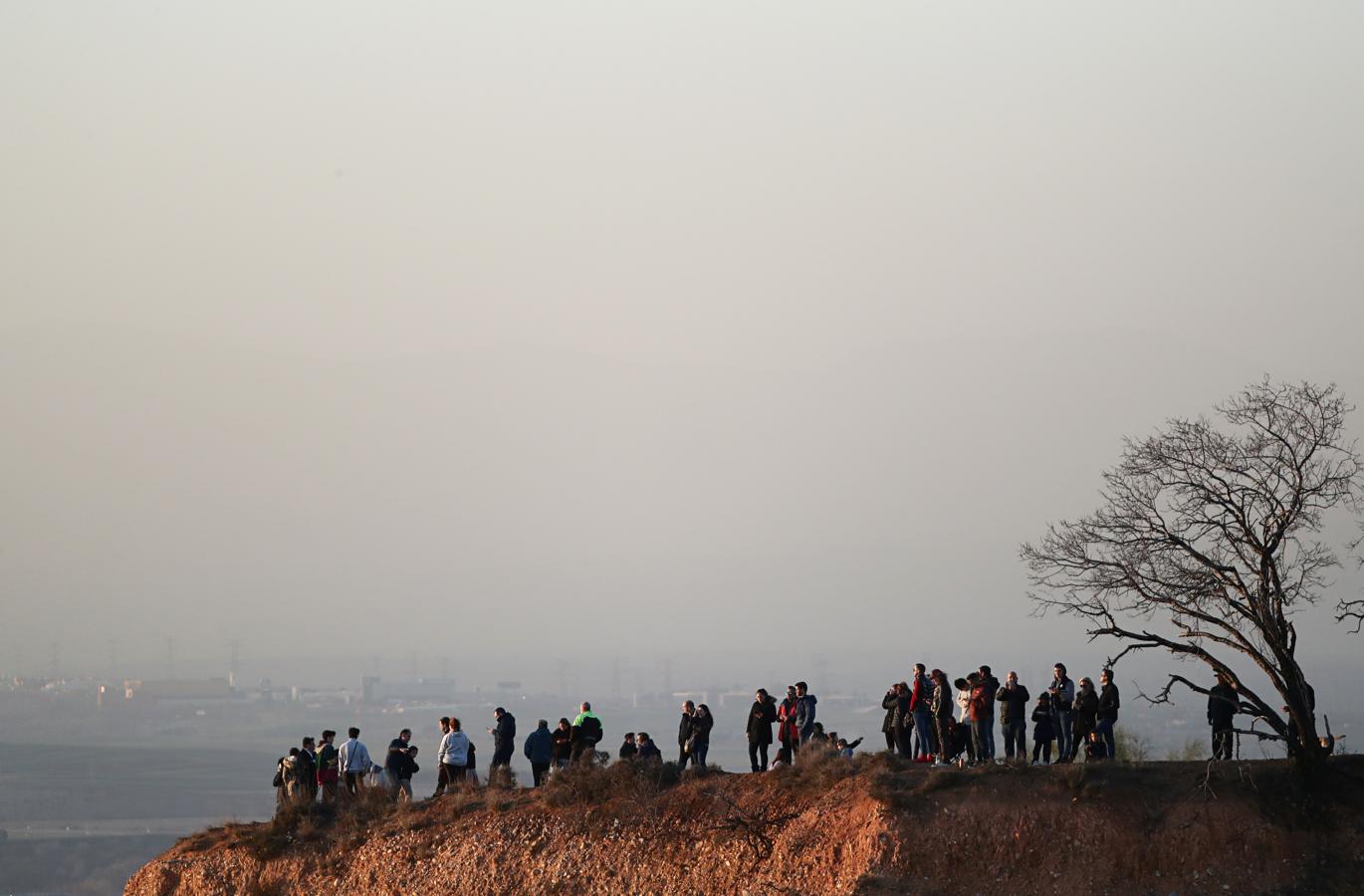 Algunas personas observan desde Paracuellos del Jarama Vista la torre de control del aeropuerto de Barajas. 