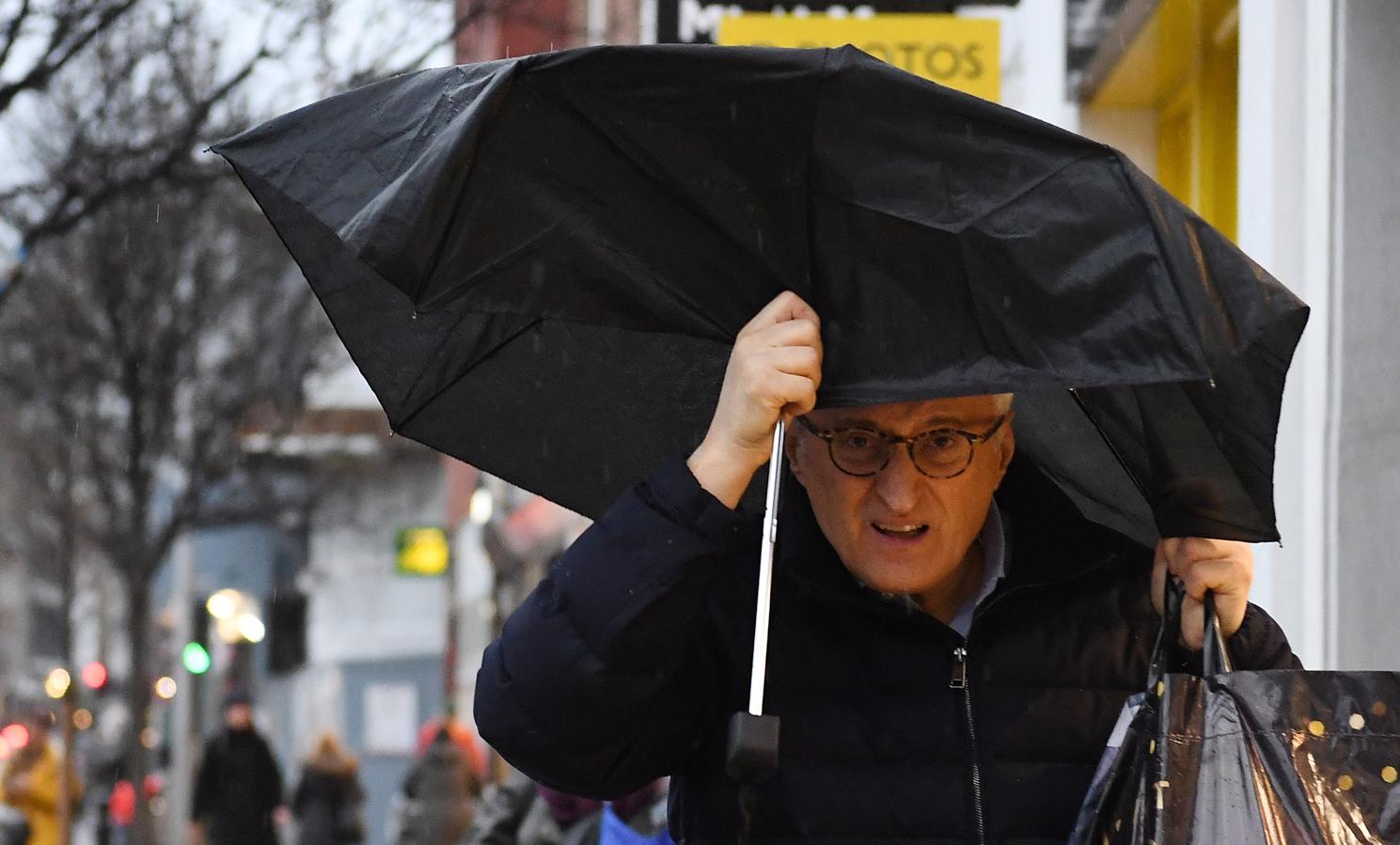 Un ciudadano hace frente al viento y a la lluvia con su paraguas roto en Londres