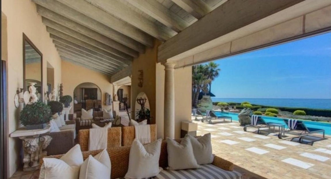 Villa de lujo en Los Monteros. El estilo mediterráneo se plasma en los suelos de terrazo, los arcos arabescos y las tejas y materiales de su cubierta. La lujosa villa de Marbella tiene un porche que, dadas las cualidades climáticas de la región, puede aprovecharse durante todo el año. El espacio está cubierto por una superficie de madera con vigas vista y se sujeta por columnas de piedra. Sus estancias están separadas por arcos