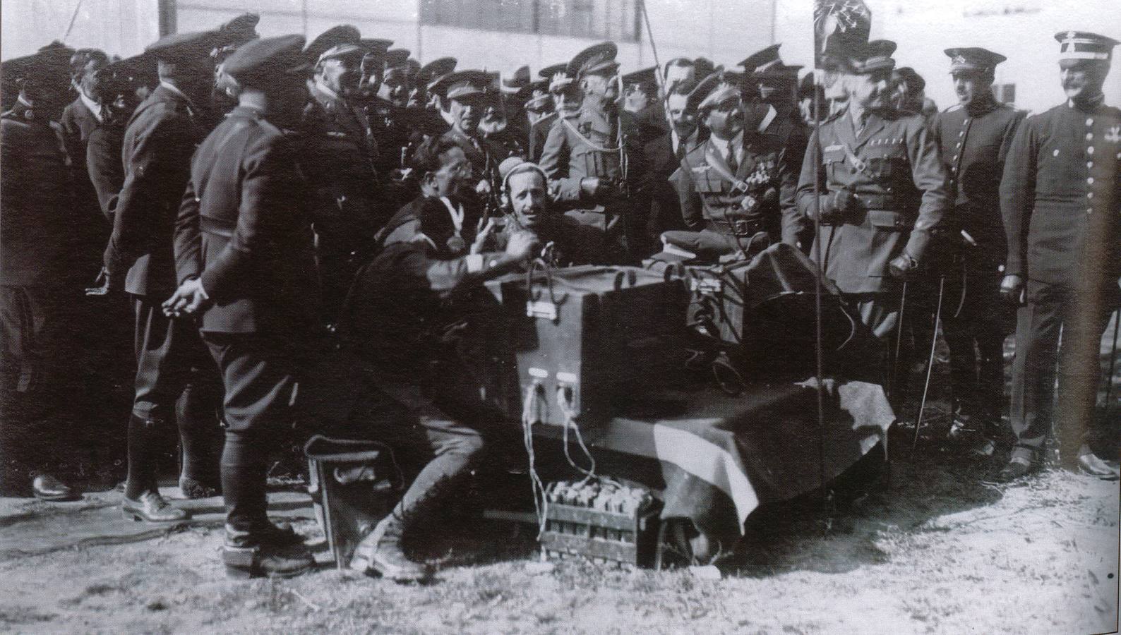 Su Majestad el Rey Alfonso XIII escucha las transmisiones radiotelegráficas con las escuadrillas en vuelo que se dirigen hacia la ceremonia de la inauguración de la base sevillana