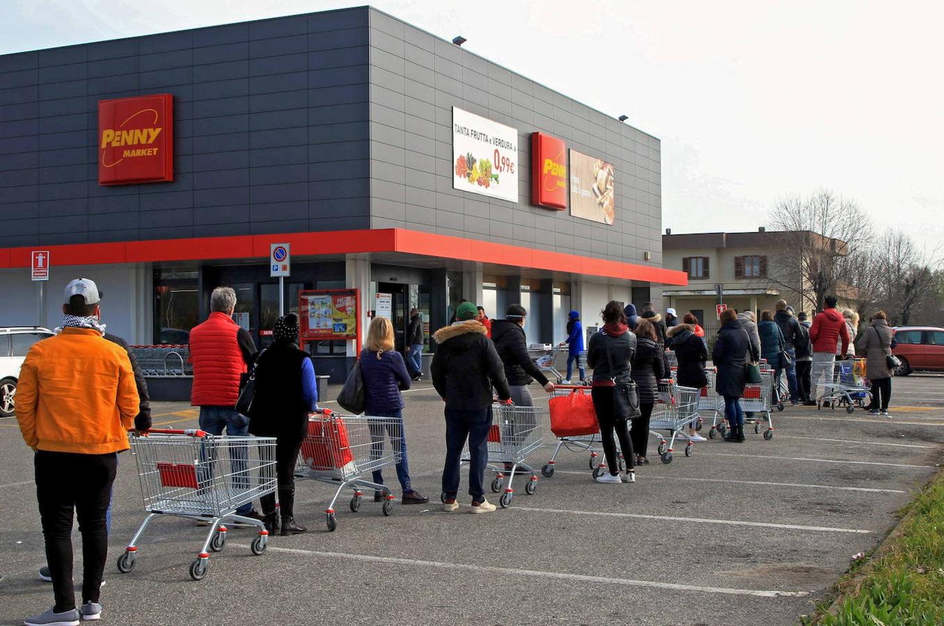 Ciudadanos italianos hacen cola en el supermercado para abastecerse. 