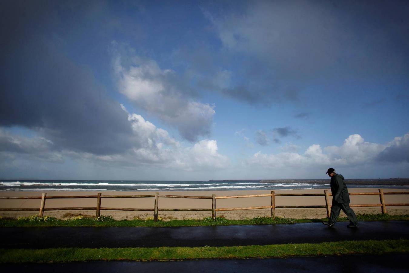 Un hombre pasea por el paseo marítimo de Arteixo este lunes. Todo el país esta en alerta por viento salvo Canarias a causa de la borrasca Karine, con rachas de hasta 120 kilómetros por hora en el sistema central, y olas que afectarán a todo el litoral y llegarán hasta los 6 metros en el Cantábrico.. 