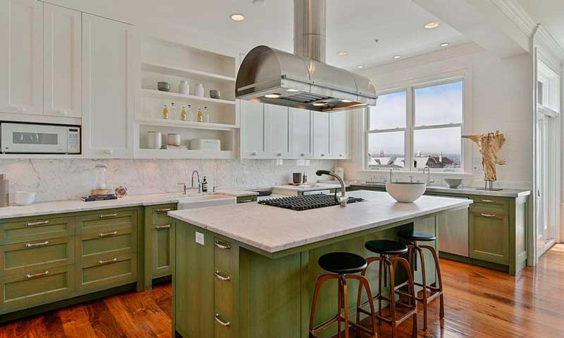 Así es la nueva casa de Julia Roberts en San Franciso. Destaca la cocin familiar, con mucha luz, encimeras de mármol, muebles en verde oliva y una isla que cuenta con una zona de fuegos -con una curiosa campana estractora encima-, superficie de trabajo con tres taburetes y espacio para almacenaje.