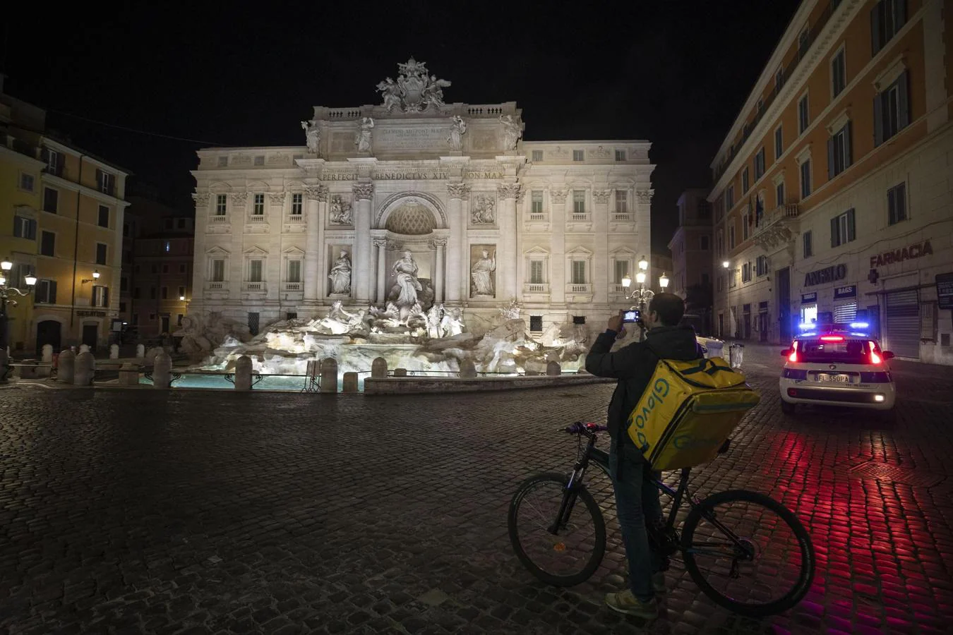 Roma. Un operario de Glovo inmortaliza la Fontana de Trevi la noche del miércoles en Roma, vigilada por la Policía. Jamás se verá en ese estado