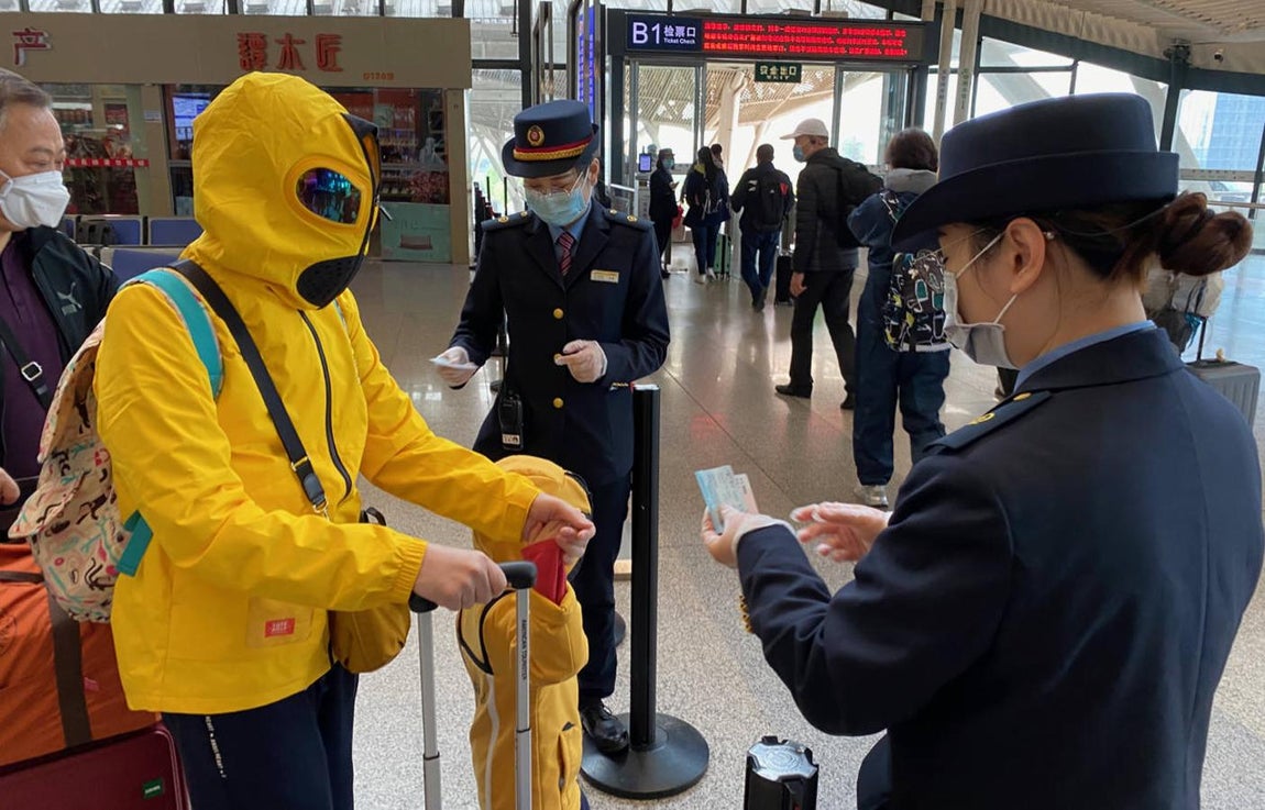 Cubriéndose el torso y la cabeza, una madre y su hijo visten una especie de traje "zentai" japonés que parece un disfraz de mosca o alienígena. 
