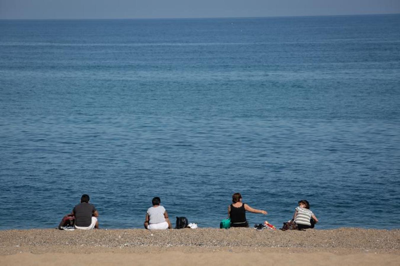 Varias personas sentadas en la Playa de la Barceloneta este miércoles 20. 