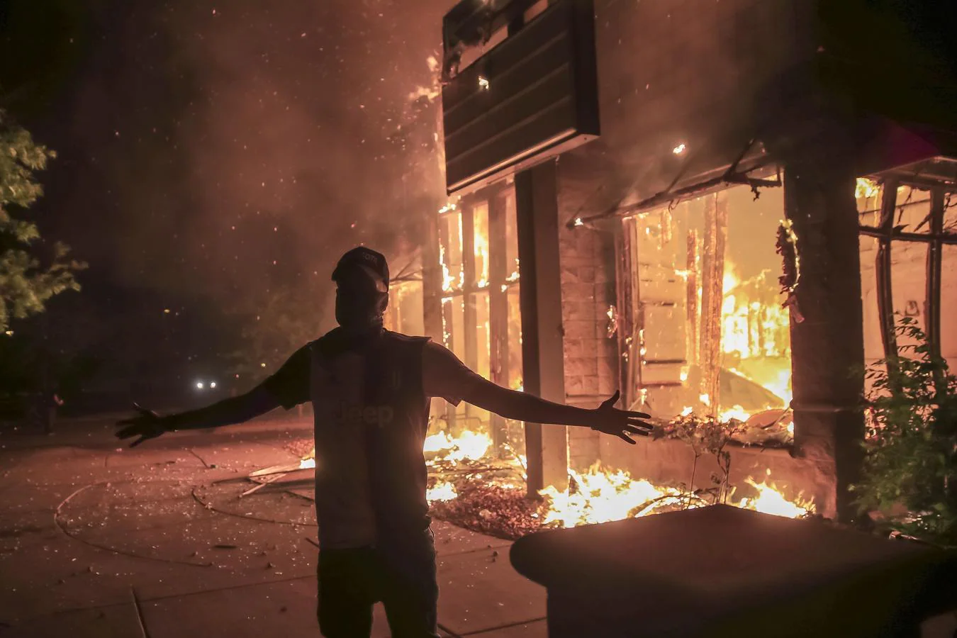 Disturbios en Mineápolis. Un manifestante, frente a un comercio preso de las llamas en Mineápolis