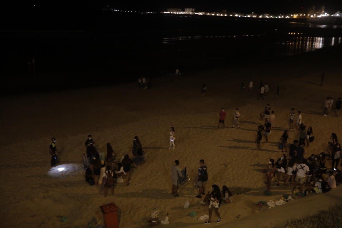FOTOS: Unos 1.000 jóvenes son desalojados de la playa en Cádiz cuando hacían botellón por San Juan
