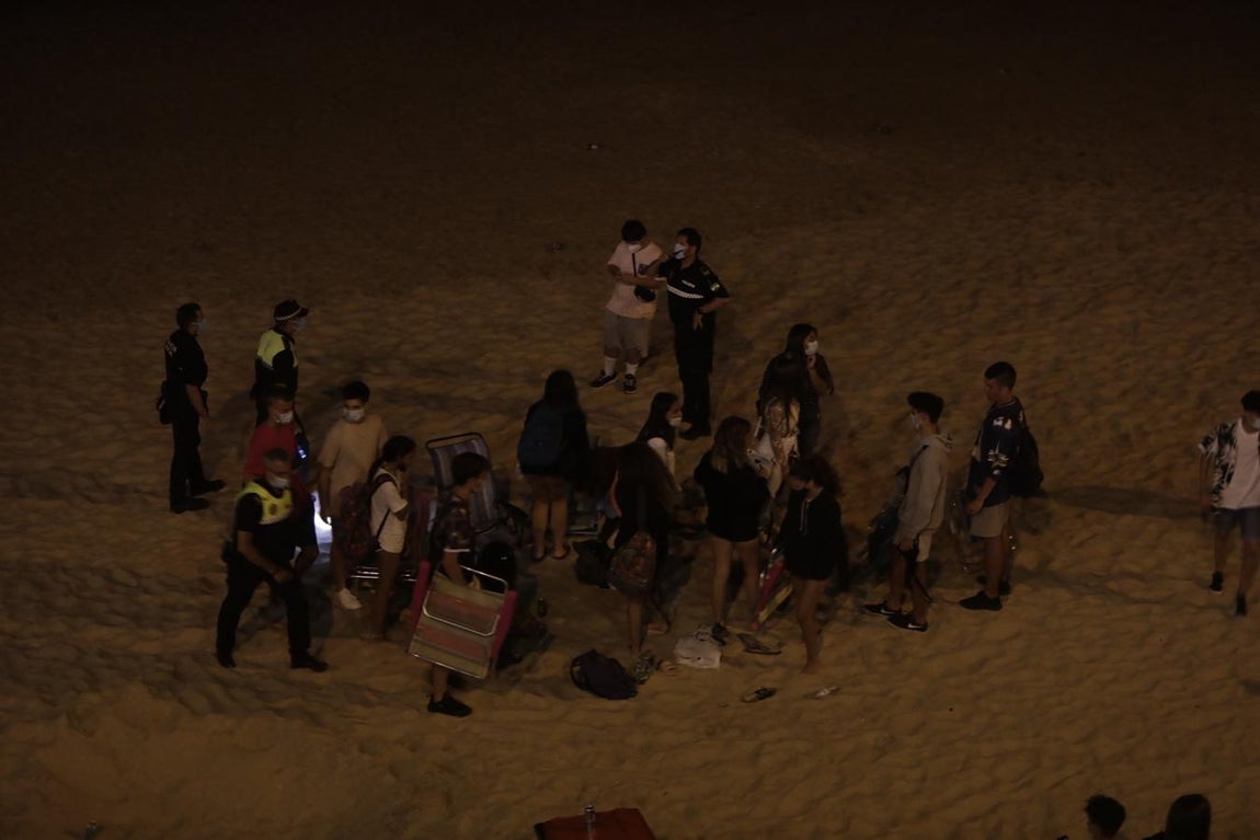 FOTOS: Unos 1.000 jóvenes son desalojados de la playa en Cádiz cuando hacían botellón por San Juan