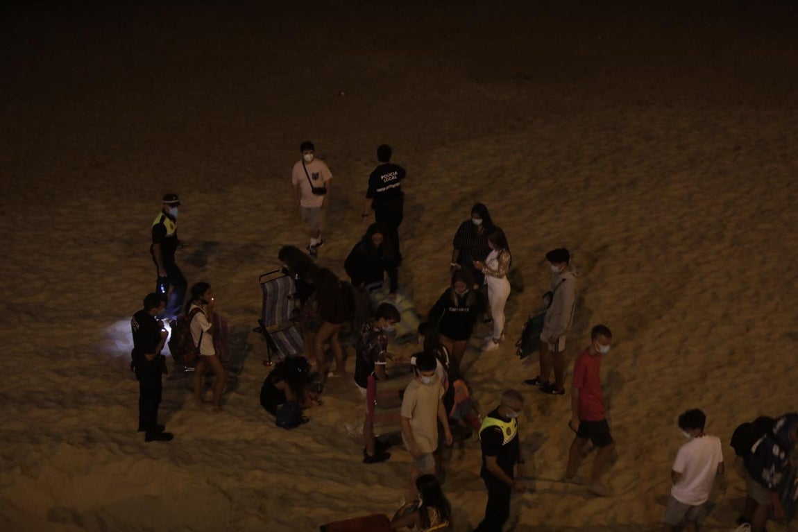 FOTOS: Unos 1.000 jóvenes son desalojados de la playa en Cádiz cuando hacían botellón por San Juan