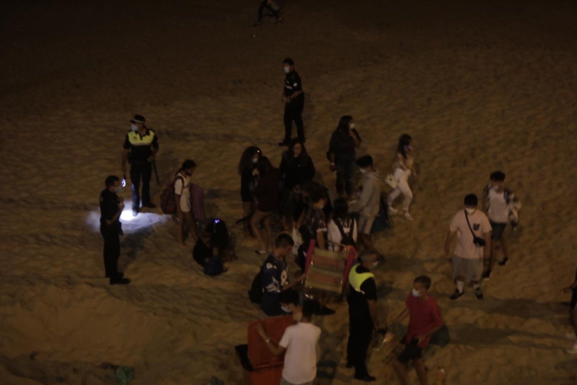 FOTOS: Unos 1.000 jóvenes son desalojados de la playa en Cádiz cuando hacían botellón por San Juan
