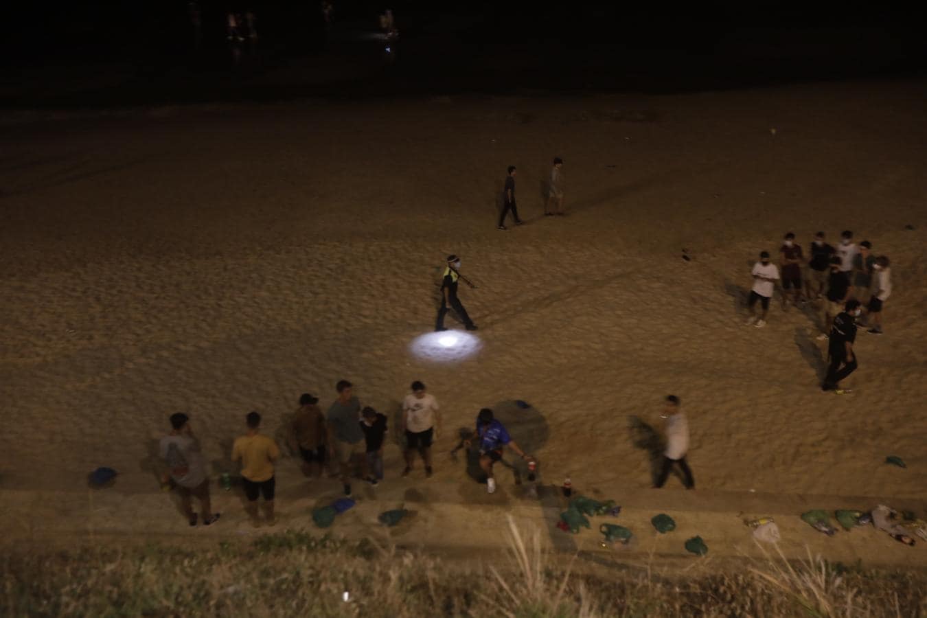 FOTOS: Unos 1.000 jóvenes son desalojados de la playa en Cádiz cuando hacían botellón por San Juan