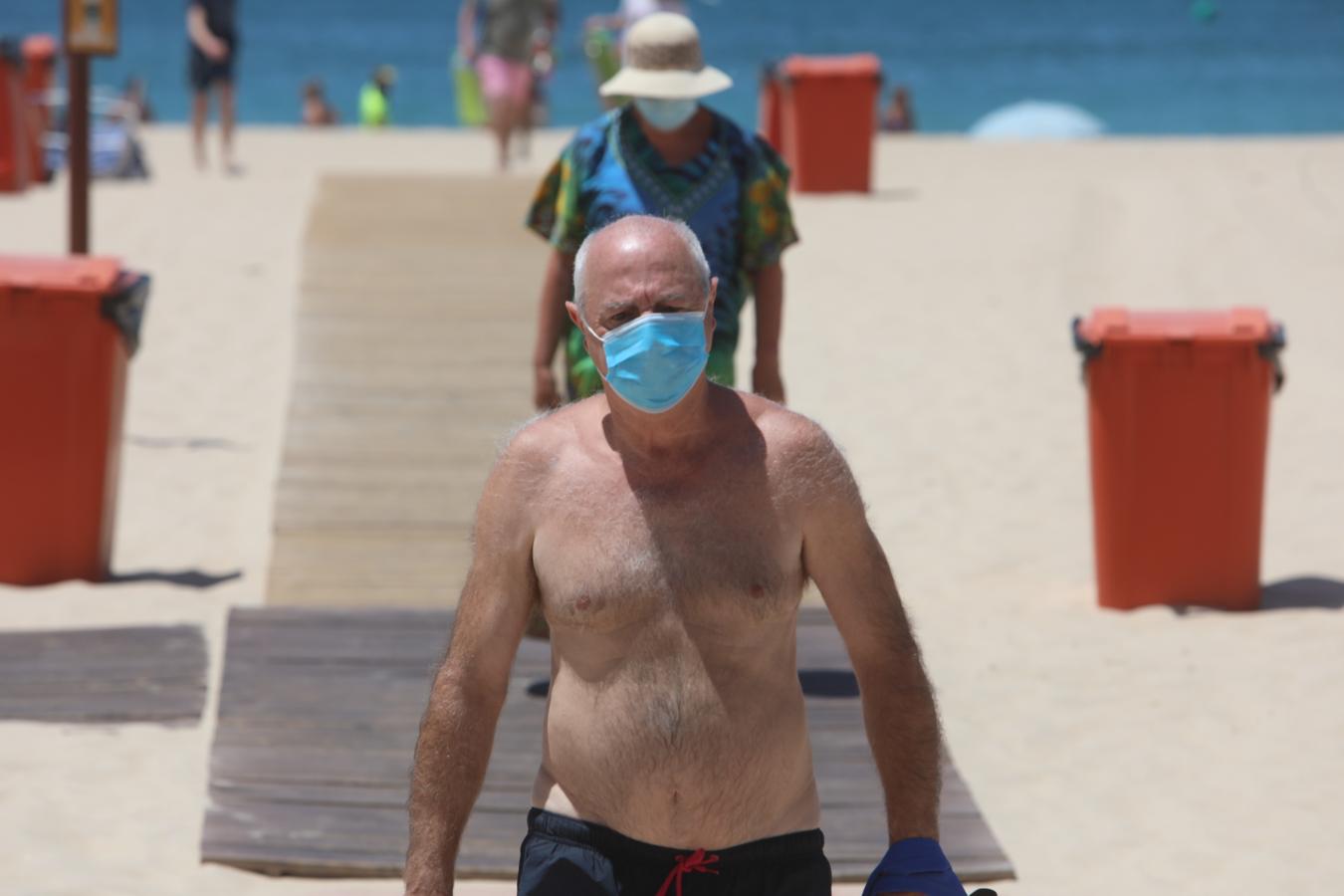 Fotos: Bañistas concienciados en Cádiz con el uso de la mascarilla