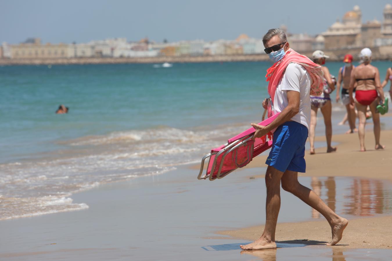 Fotos: Bañistas concienciados en Cádiz con el uso de la mascarilla