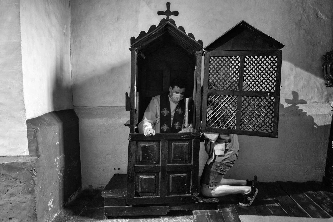 Cangas del Narcea, Asturias - Mayo 2020: El padre Juan Jose Blanco se protege con una macarilla mientras imparte el sacramente de la confesión.. 