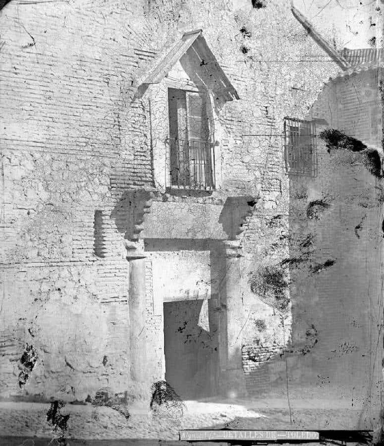 Puerta gótica del palacio de Caracena en la calle de la Ciudad. Sobre ella el balcón del salón principal bajo un tejaroz de madera ya perdido. Fotografía de Casiano Alguacil hacia 1885. Archivo Municipal de Toledo. 