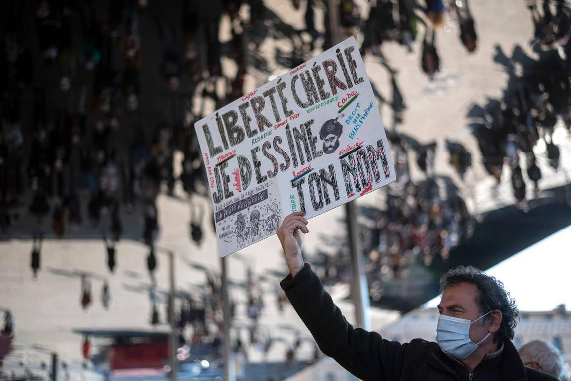 Un hombre sostiene una pancarta que dice «Libertad apreciada, saco tu nombre». 