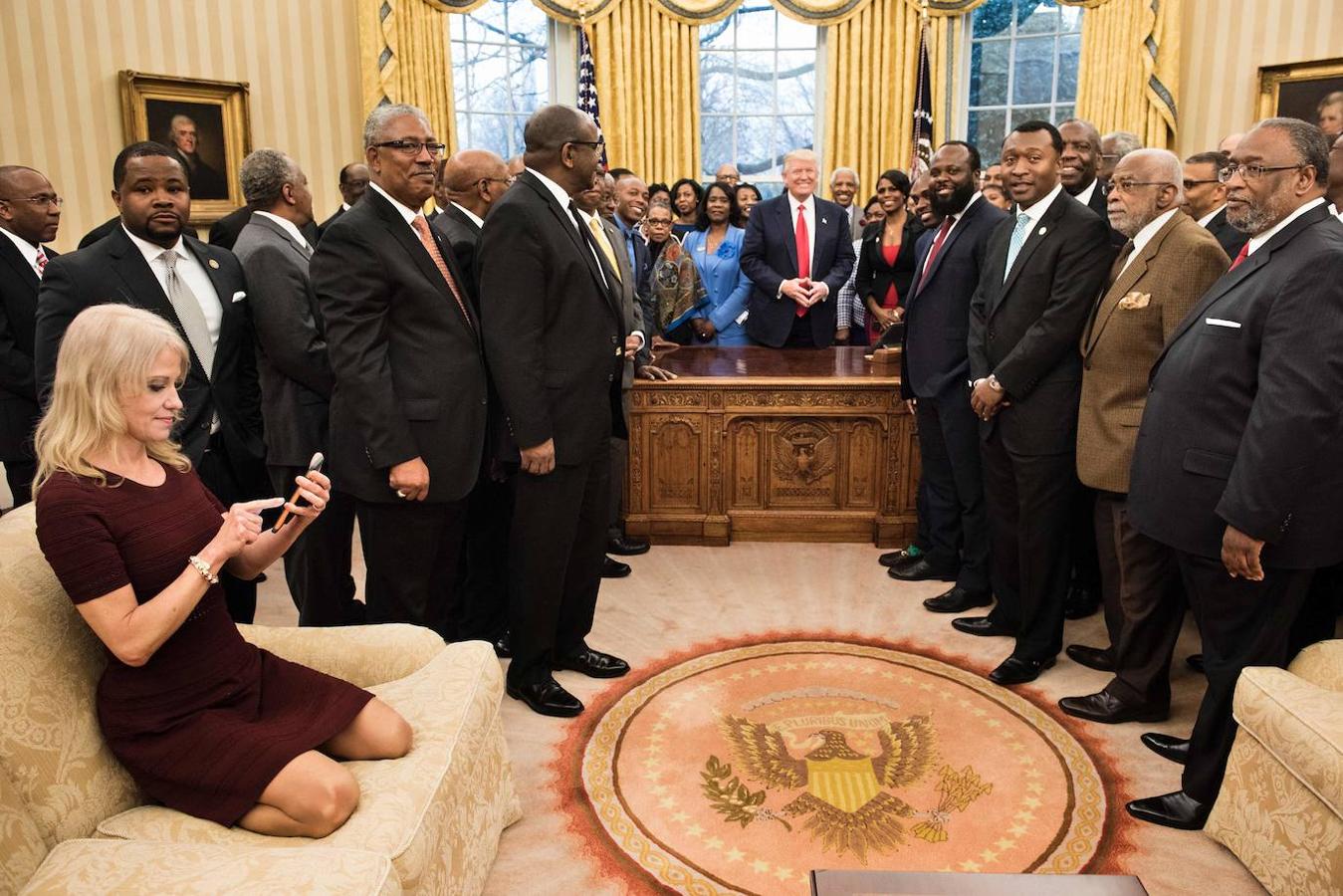 La consejera presidencial de Trump, Kellyanne Conway, revisa su teléfono móvil tras tomar fotos del presidente con líderes negros históricos de universidades y colegios el 27 de febrero de 2017 en el Despacho Oval.. 