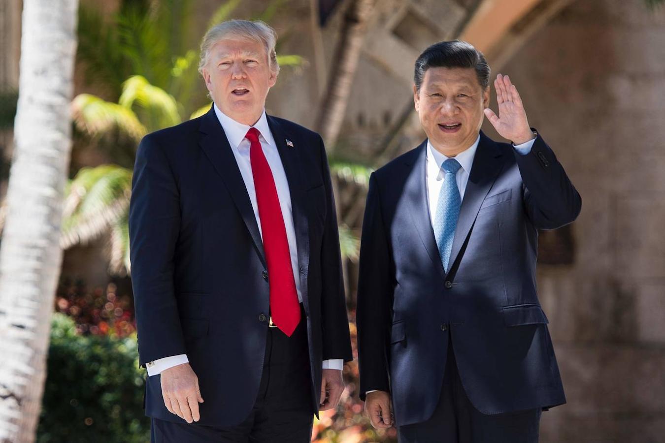 El presidente chino, Xi Jinping, saluda a la prensa mientras camina con su homólogo estadounidense por Mar-a-Lago, la residencia que tiene Trump en West Palm Beach, en Florida.. 