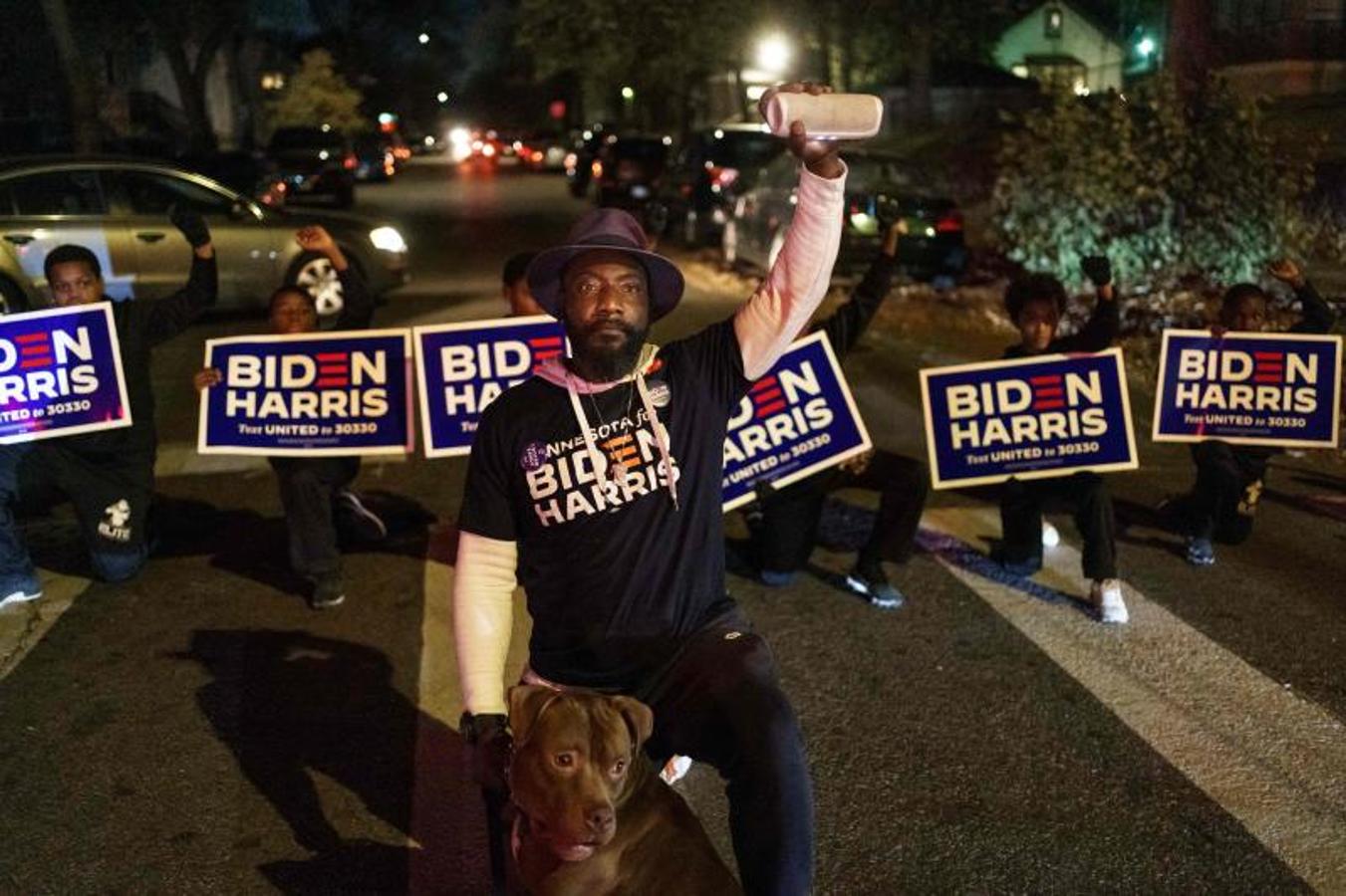 Un grupo de niños muestran su apoyo al candidato presidencial Joe Biden y se arrodillan y bloquean la carretera cerca de un colegio electoral en Minneapolis, Minnesota. 