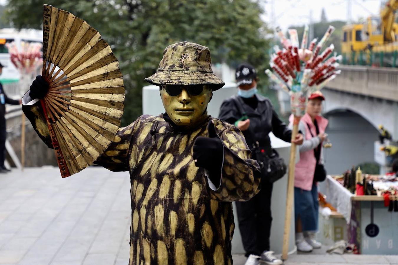 Ataviado con ropajes que recuerdan a la moda de los años 30 y 40 en China, un artista callejero da ánimos en Wuhan. 