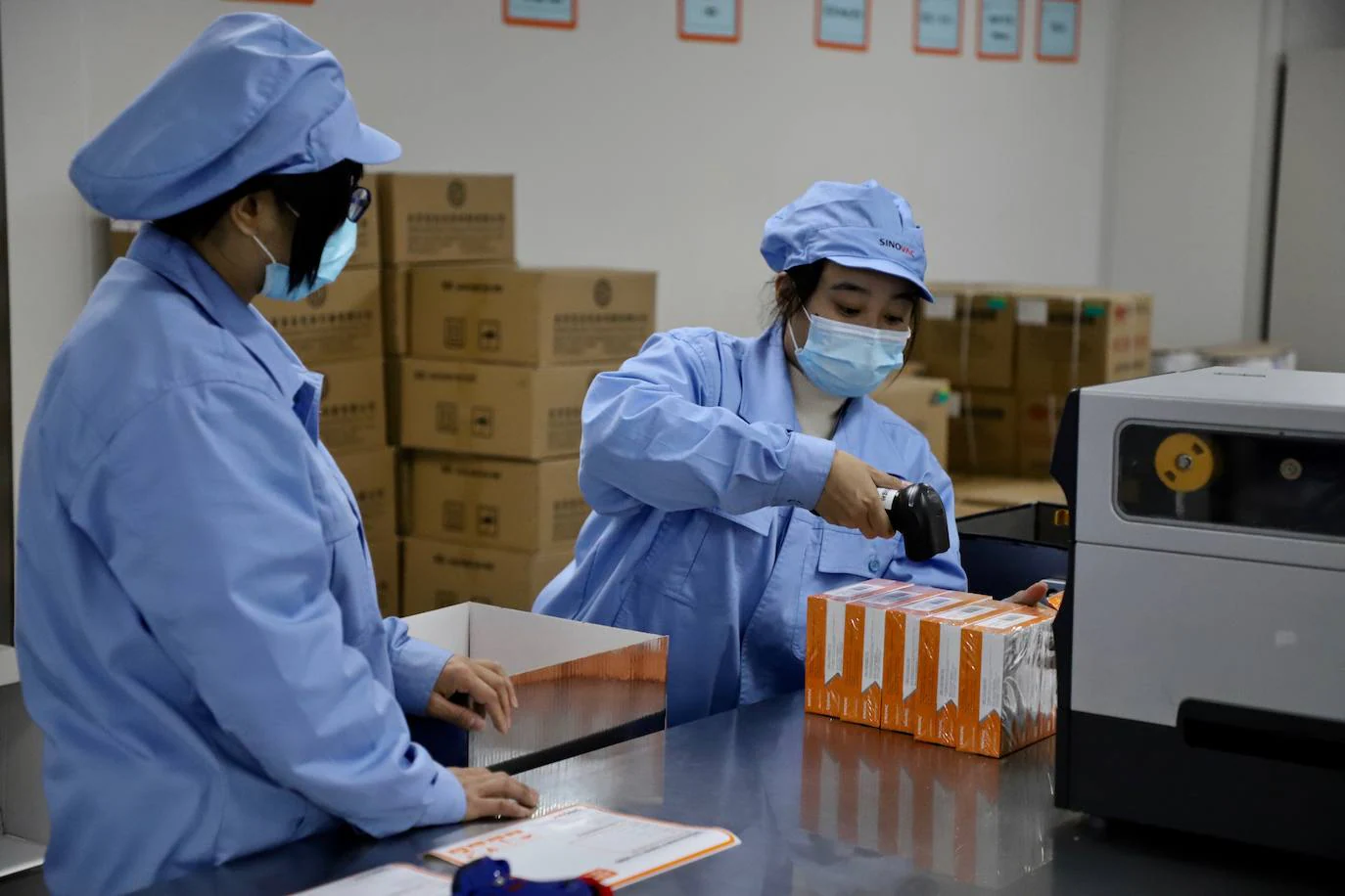 Dos empleadas de Sinovac empaquetan las vacunas contra el coronavirus, que se están inoculando de emergencia antes de ser aprobadas. 