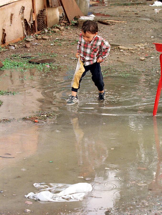 Un niño salta sobre un enorme charco provocado en una de las continuas inundaciones del asentamiento