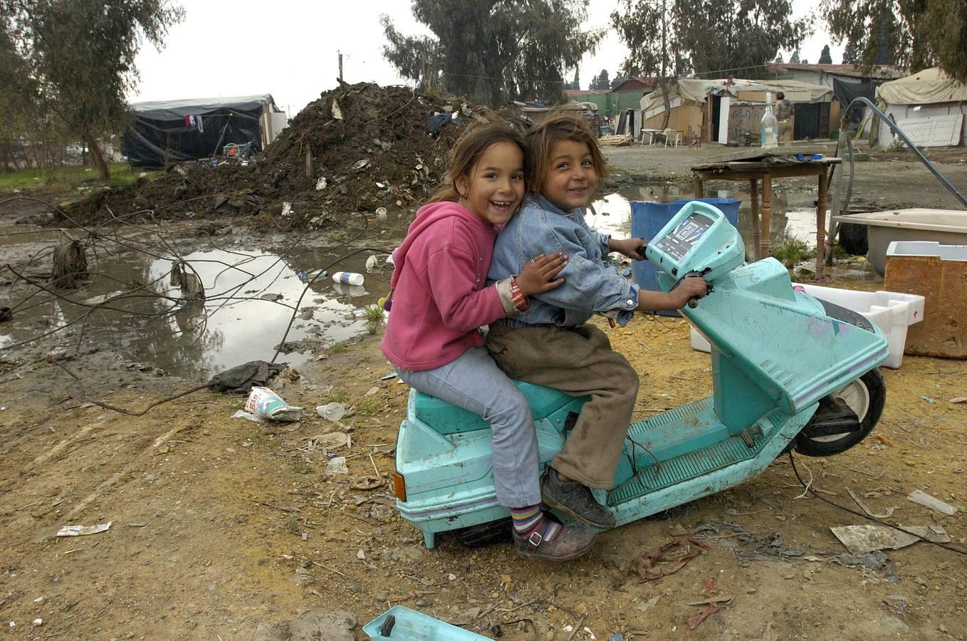 Dos niños juegan sonrientes sobre una réplica de Vespa entre la inmundicia del Vacie