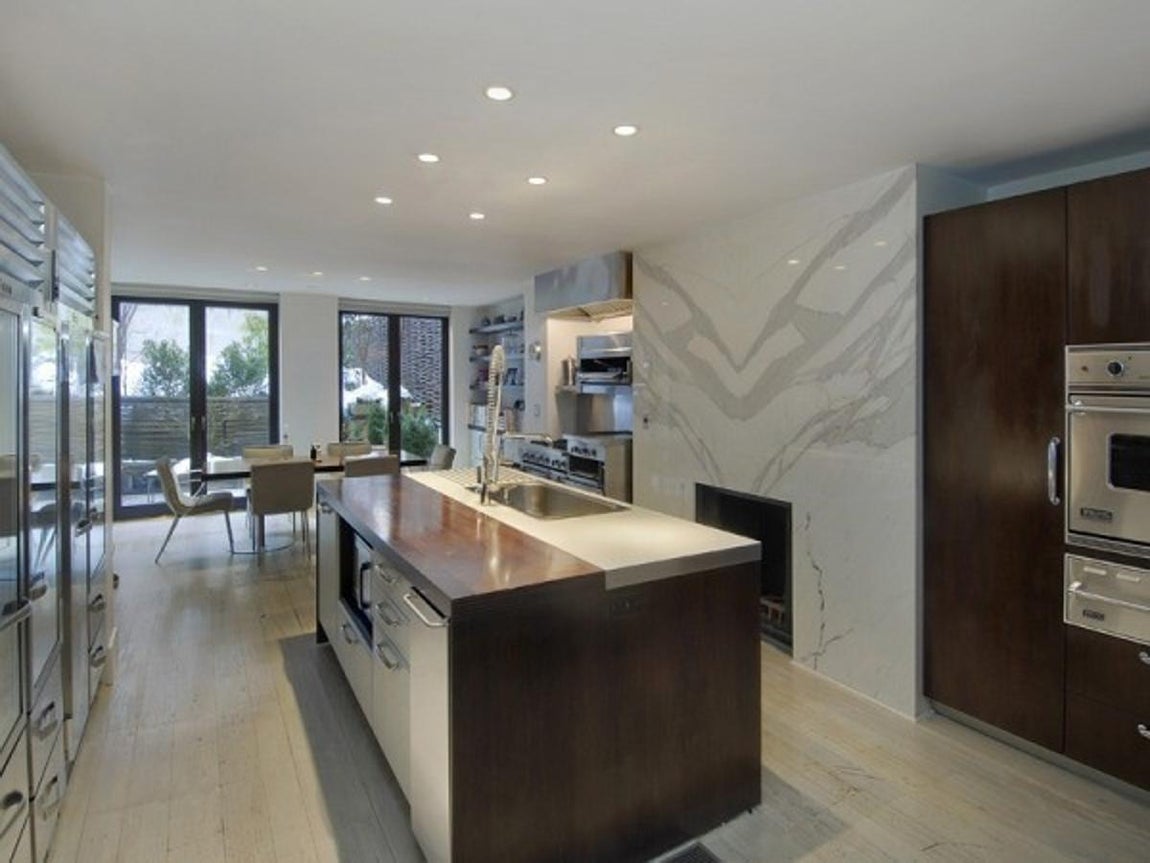 La casa que Sarah Jessica Parker ha vendido en Nueva York. La cocina es bastante amplia y comunica con el comedor y a su vez con una de las terrazas. La mayoría del mobiliario está realizado en mármol y no podía faltar tampoco una gran isla central.