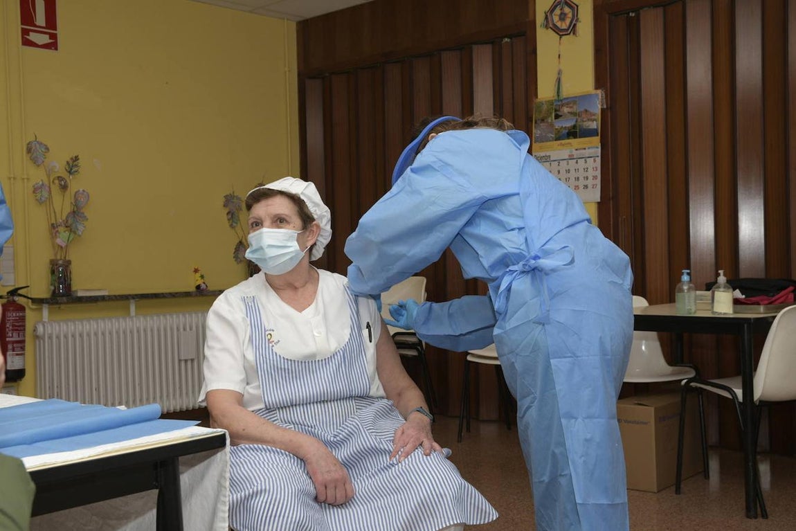 Una cocinera del centro, Juli es vacunada tras el primer hombre en vacunarse en La Rioja, durante el primer día de vacunación contra la Covid-19 en España. 