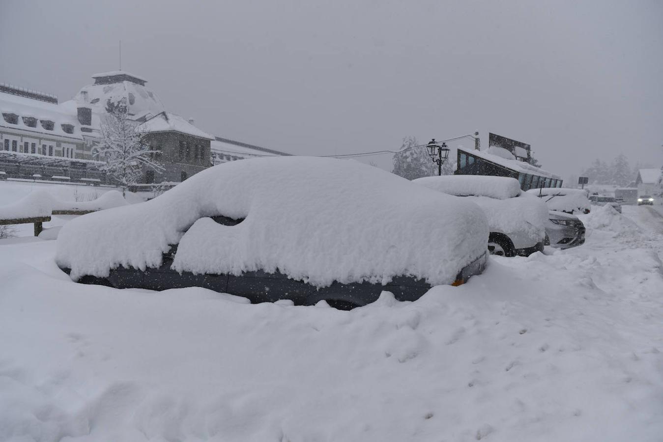 Coches cubiertos de nieve en el Pirineo aragonés. La alerta roja por nieve tras la borrasca Bella se mantiene este martes en 14 carreteras del Pirineo aragonés, donde es obligatorio el uso de cadenas y está prohibida la circulación a camiones, autobuses y vehículos pesados en varios puntos del norte de la provincia de Huesca