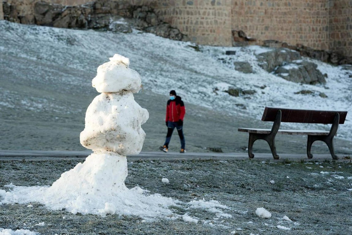 Un hombre pasea junto al lienzo norte de la muralla de Ávila donde la nieve ha dado paso al hielo por las bajas temperaturas registradas durante la madrugada. 