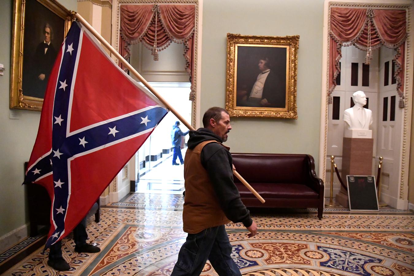 Un hombre lleva una bandera confederada durante el asalto al Capitolio de Estados Unidos. 