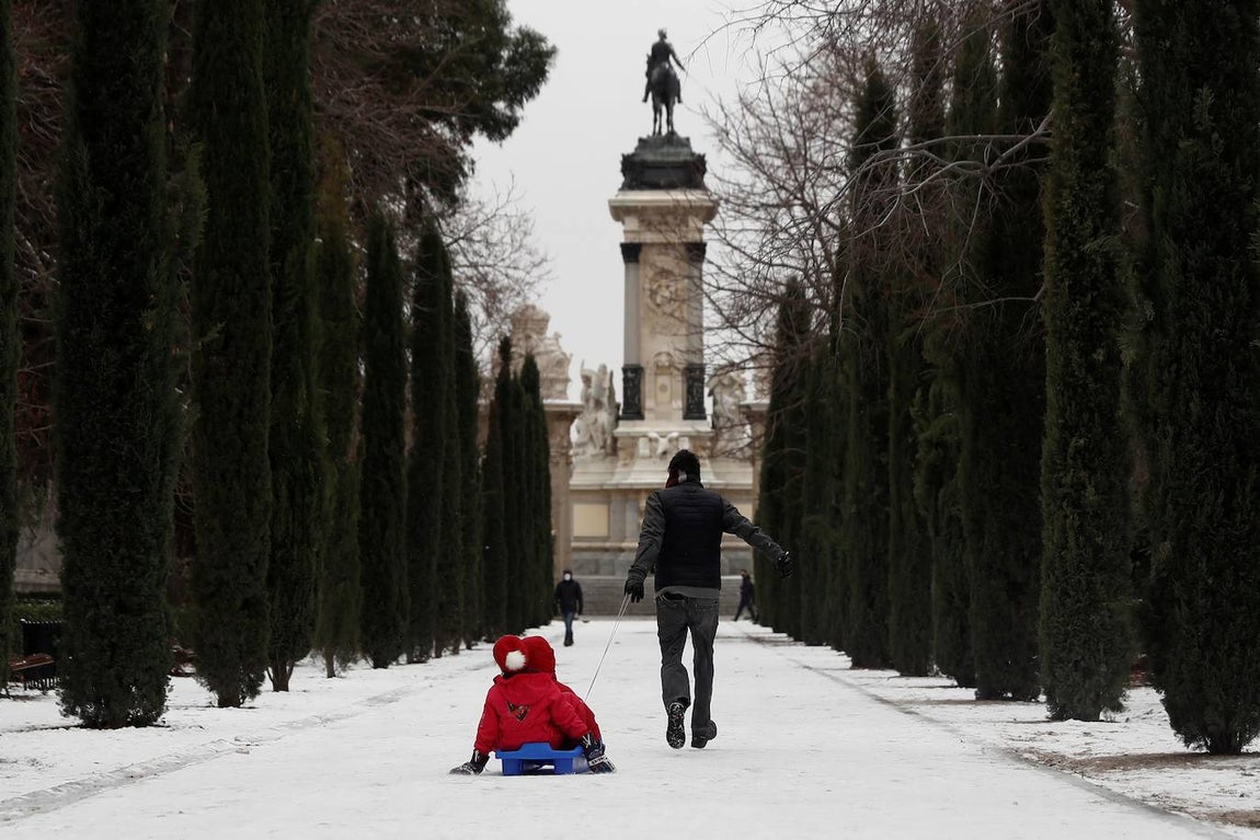 Una familia juega con el trineo en El Retiro. 