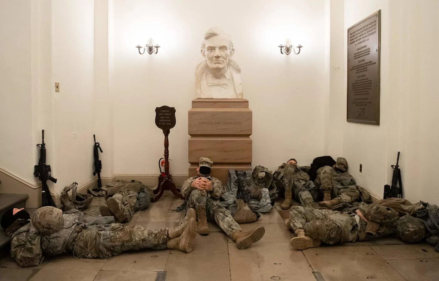 Miembros de la Guardia Nacional descansan en la Rotonda del Capitolio de Washington, justo debajo de la gran cúpula del edificio, a la espera de que concluya la votación de «impeachment» al presidente saliente, Donald Trump.. 