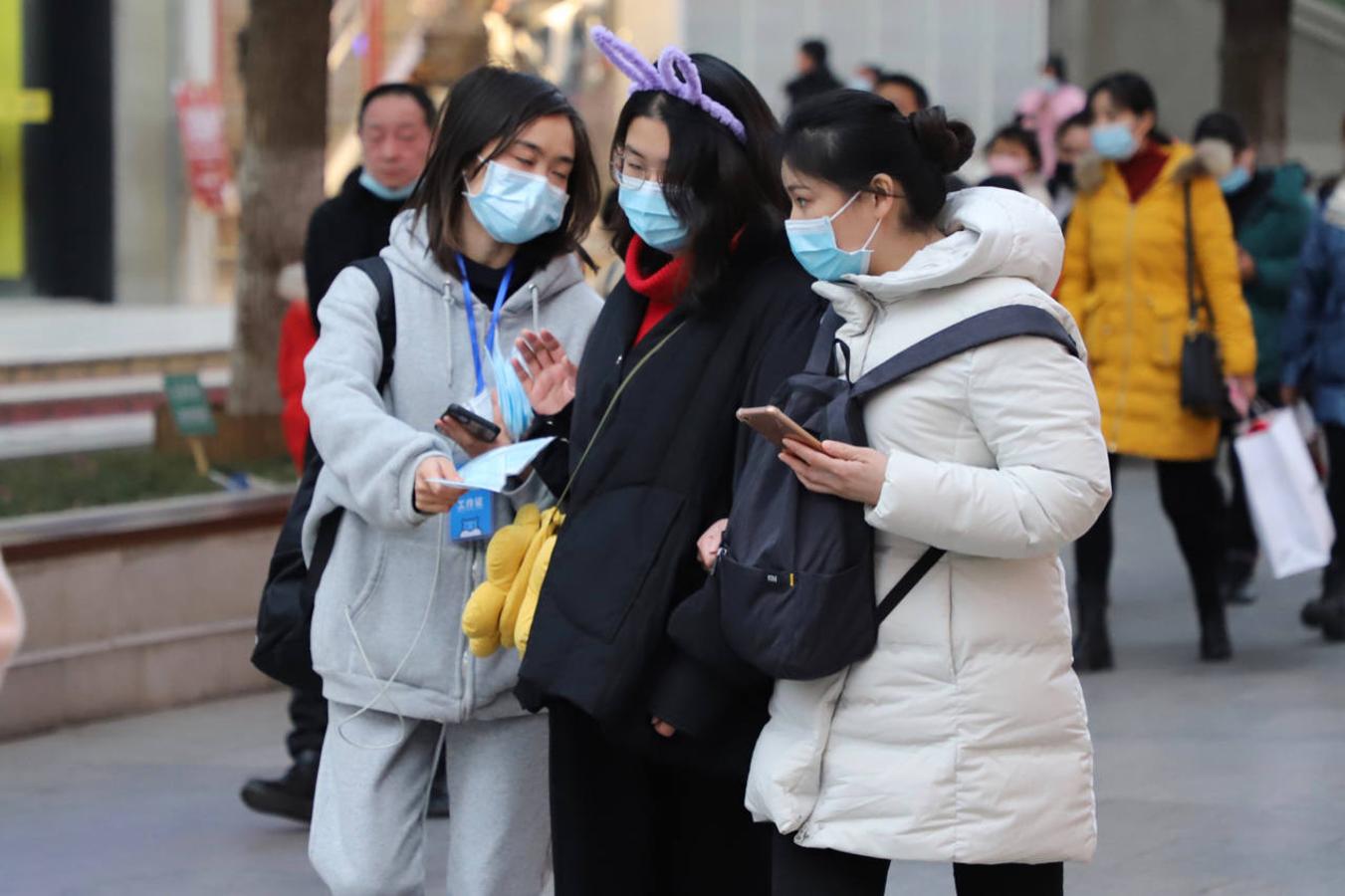 Una famosa cadena china de supermercados se promociona en Wuhan repartiendo mascarillas en la popular calle Jianghan. 