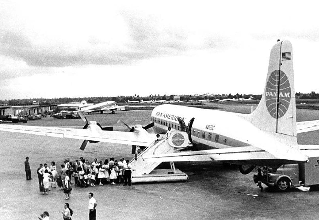 Niños cubanos suben a un avión comercial en Cuba rumbo a EE.UU.. 