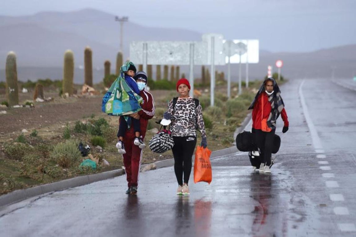 Una familia venezolana cruza a pie la frontera entre Bolivia y Chile. 