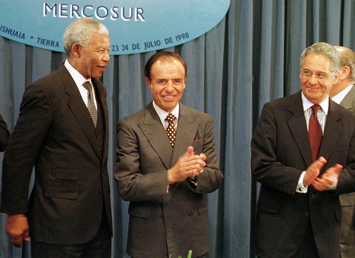 Carlos Menem y Fernando Henrique Cardoso (derecha), entonces presidentes de Argentina y Brasil respectivamente, aplauden al entonces presidente sudafricano Nelson Mandela, quien participó en la reunión de Mercosur como invitado. 