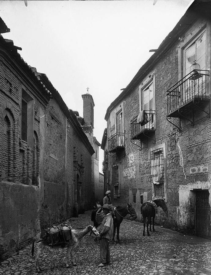 Foto de Abelardo Linares de la calle Santa Isabel (ca. 1915), aún con el primitivo empedrado sin aceras. En medio, un aguador y otro vendedor posan con sus caballerías. En realidad, ellos eran parte de los figurantes visibles en muchas de las postales ilustradas con «personajes típicos». Archivo Municipal de Toledo. 