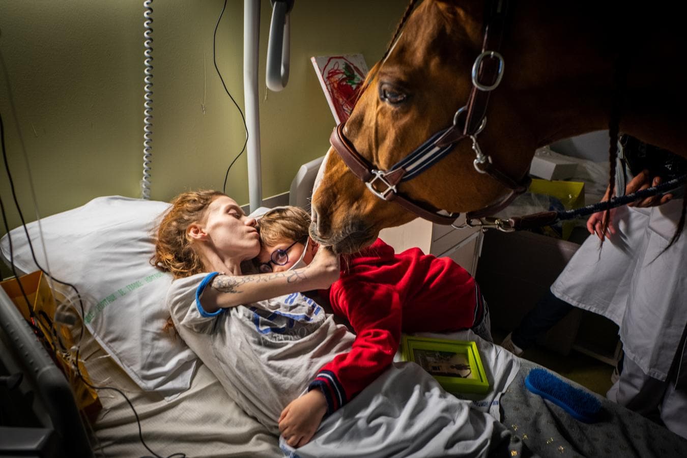 (Fotografía individual nominada en 'Temas contemporáneos') Marion, de 25 años, que tiene cáncer con mestástasis, abraza a su hijo Ethan, de siete años, en presencia de Peyo, un caballo utilizado en terapia asistida por animales en la Unidad de Cuidados Paliativos Séléne del Centre Hospitalier de Calais, en Francia. 
