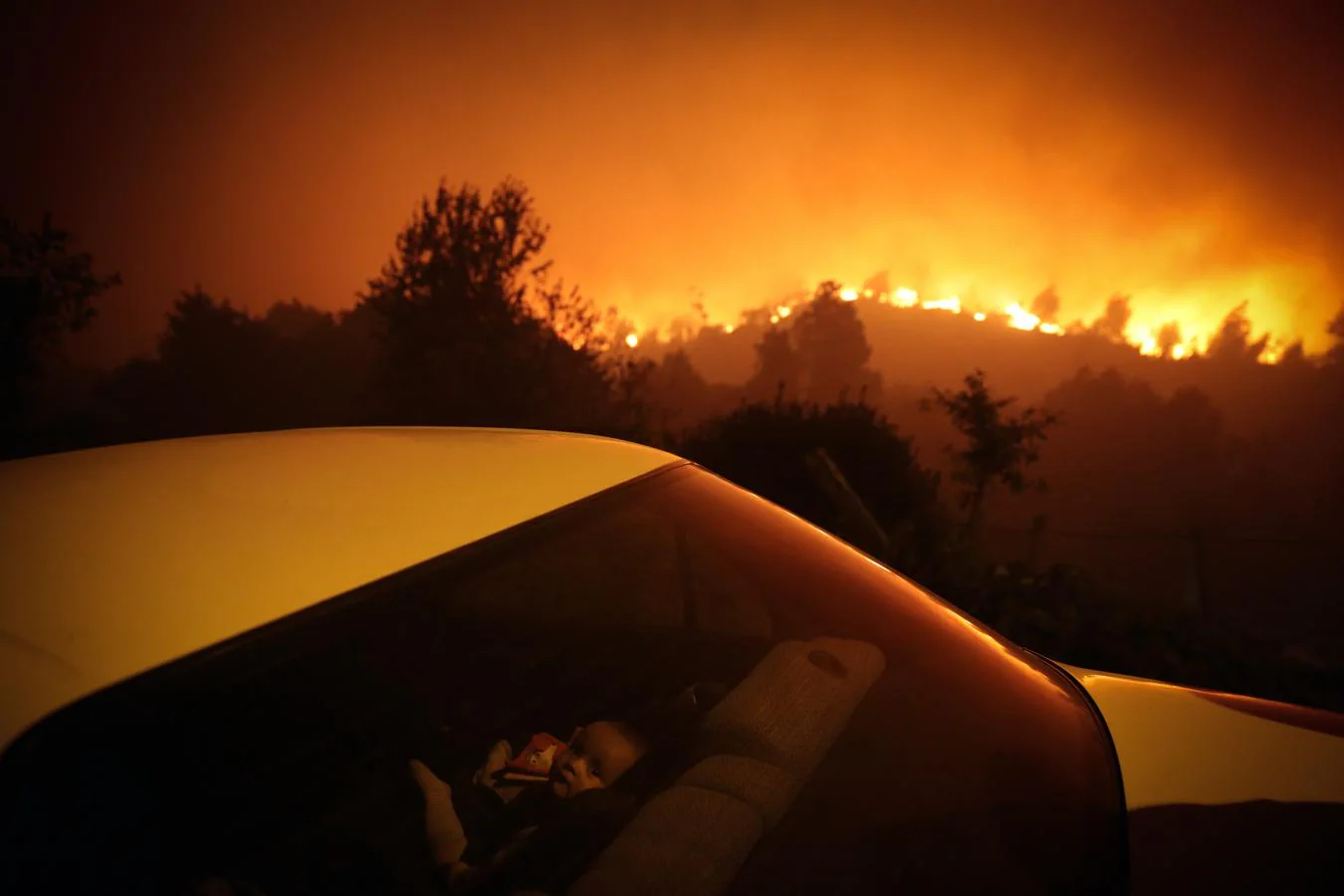 (Fotografía individual de actualidad) Un niño se sienta en un coche cerca de un incendio forestal en Oliveira de Frades, Portugal, el 7 de septiembre. 