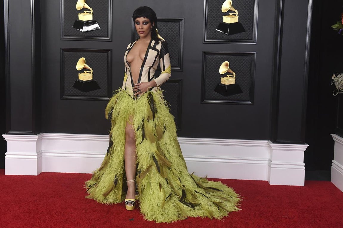 Doja Cat, en la alfombra roja de los Premios Grammy 2021. Con vestido con escote de vértigo y plumas verdes de Roberto Cavalli.