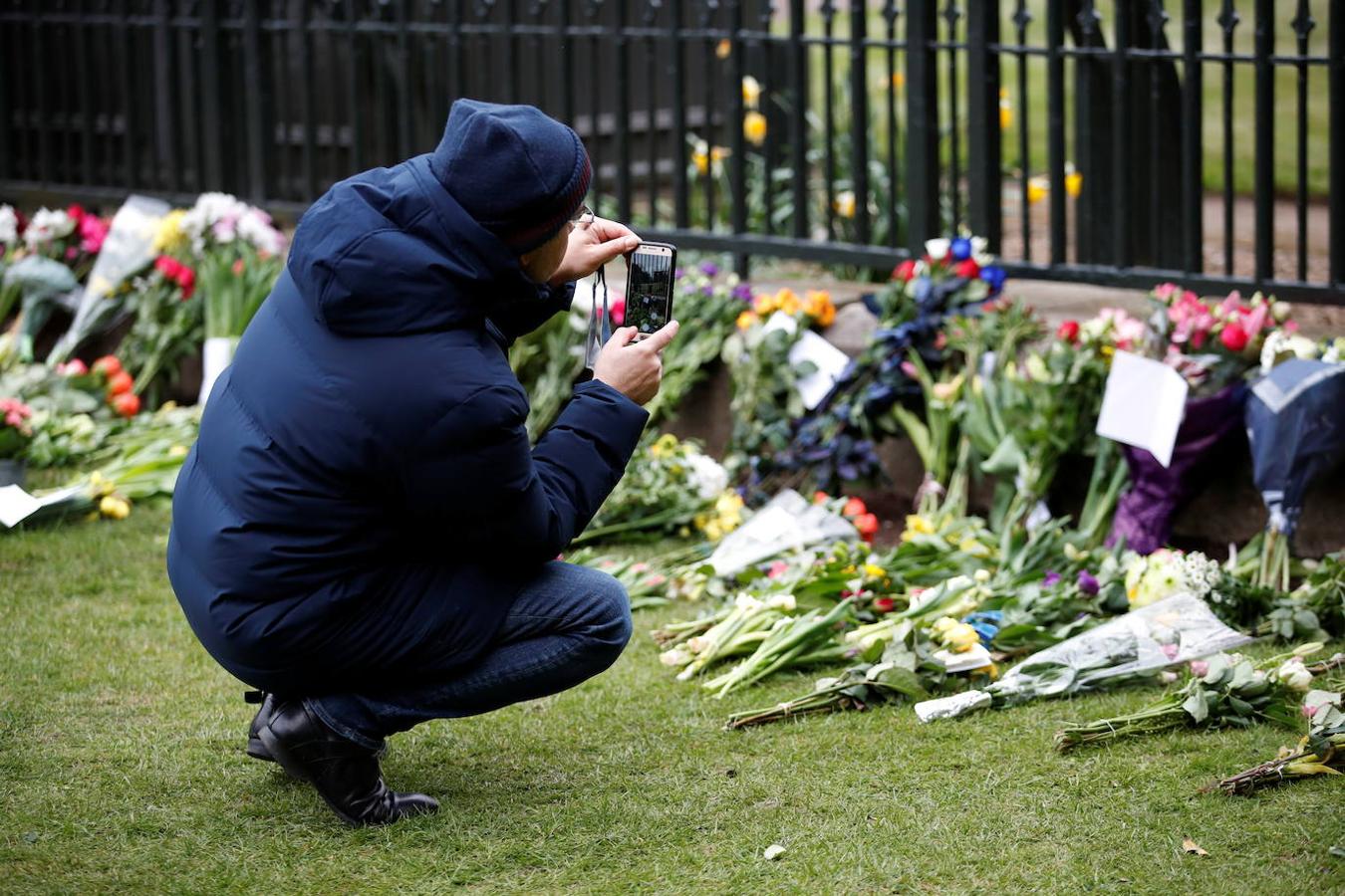 Una persona hace fotos a las flores en honor del fallecido Duque de Edimburgo. 